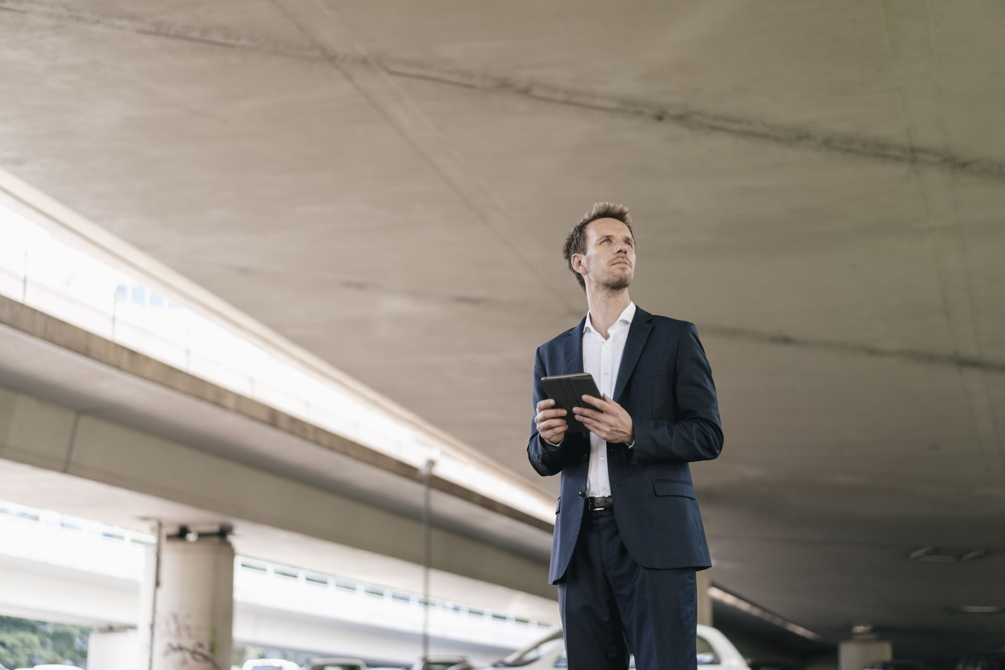 businessman-standing-at-underpass-holding-tablet-2024-09-15-09-03-05-utc